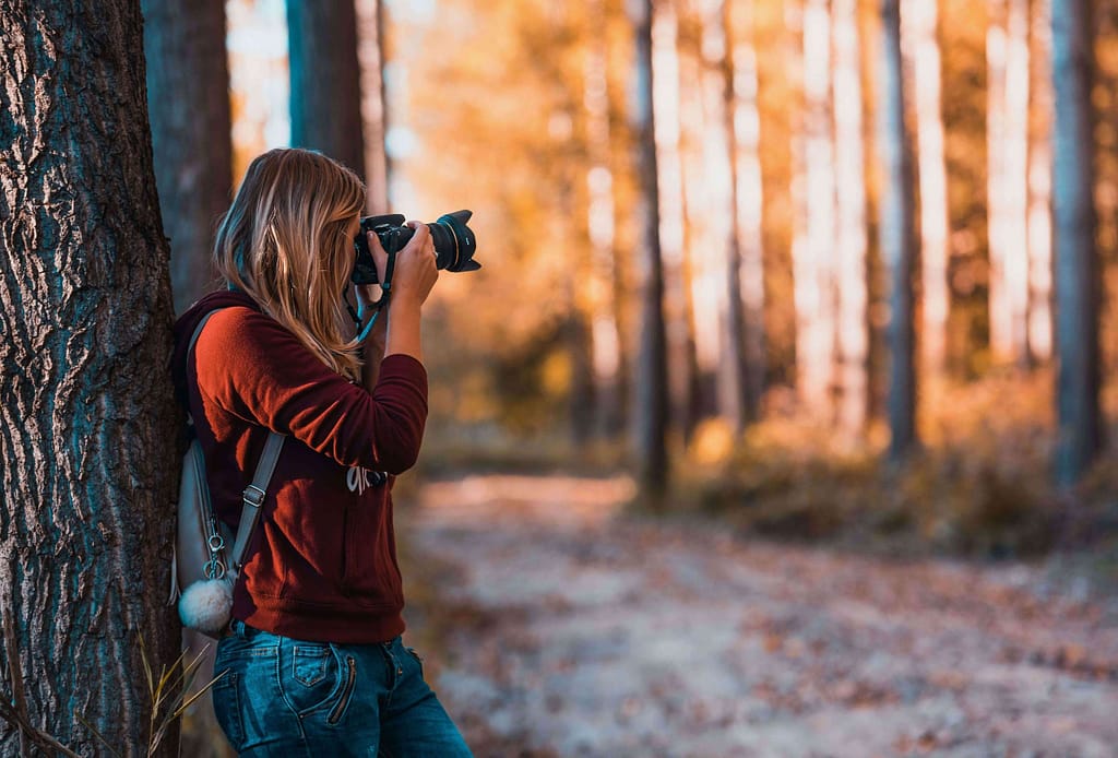 Photographer practicing landscape photography with bokeh to master depth, focus, and background blur techniques in outdoor scenes.