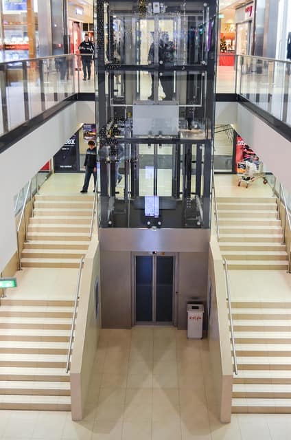 Do elevators have cameras inside a shopping mall elevator showing modern CCTV and safety monitoring system.