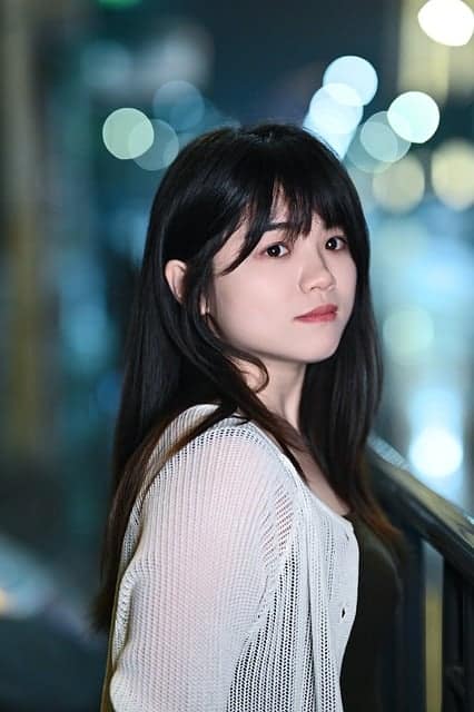 Night landscape photography with bokeh capturing glowing city lights and soft blurred reflections in low light conditions.