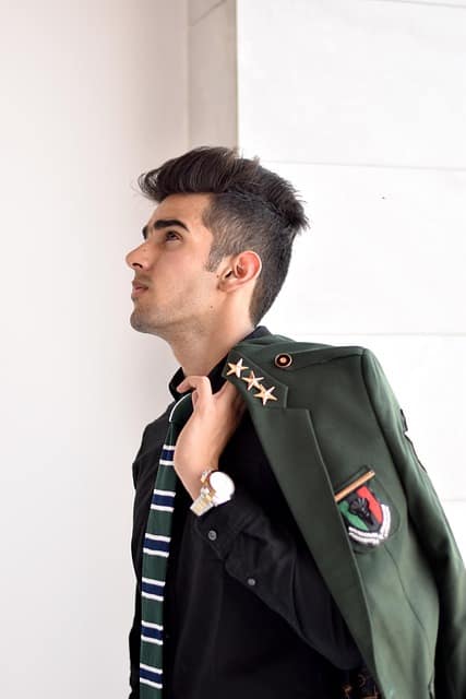 A man wearing stylish branded clothes posing confidently during a lifestyle brand photography shoot, representing modern fashion and elegance