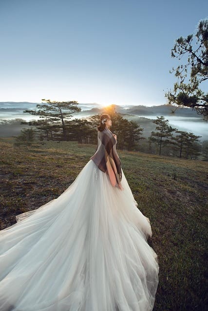 Bride posing outdoors at sunrise, captured with high-quality wedding photography lenses for a dreamy wedding portrait.