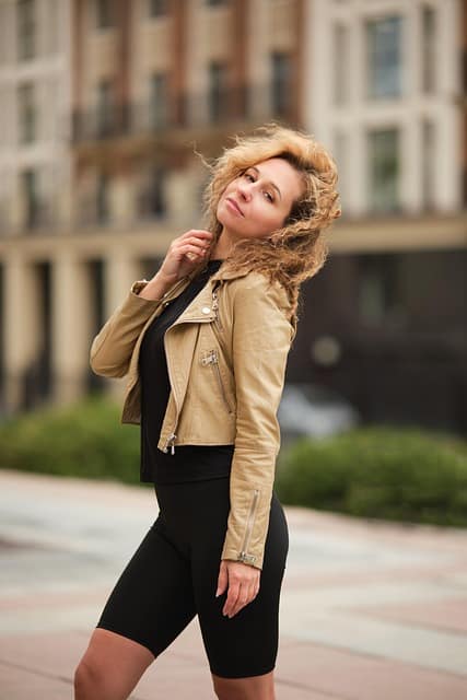 A stylish girl standing confidently on a street.