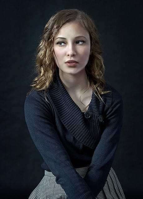 Professional woman showing what to wear in a headshot with black background