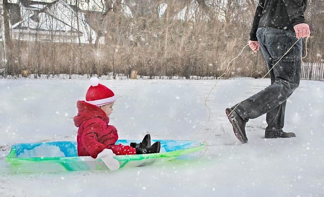 “A child playing outdoors with his father, both smiling and enjoying quality time together.