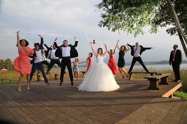 Professional wedding party photography tips example showing a perfectly posed bride, groom, bridesmaids, and groomsmen in natural light