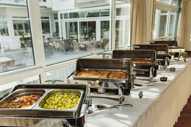 Beautiful marriage food table setup with delicious dishes, elegant table décor, and buffet arrangement for a wedding reception.