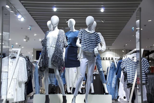 Clothes hanging neatly on racks inside a shopping mall during a lifestyle brand photography shoot, showcasing retail fashion and brand presentation.