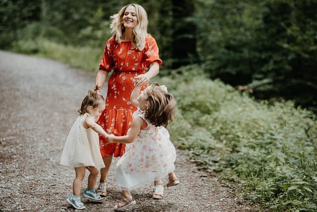 Mother with her two children smiling in a park during spring family photography session