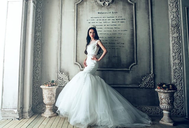 Bride in elegant gown posing for editorial style wedding photography with soft natural light