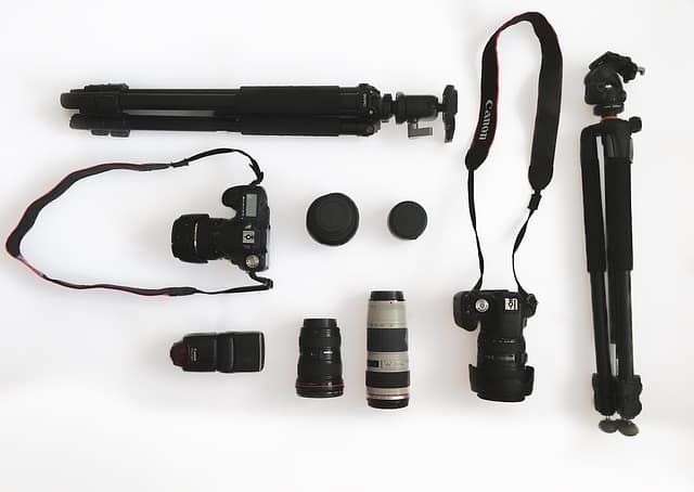 Wedding photography gear with camera accessories such as lenses, flashes, tripods, and memory cards for professional wedding shoots