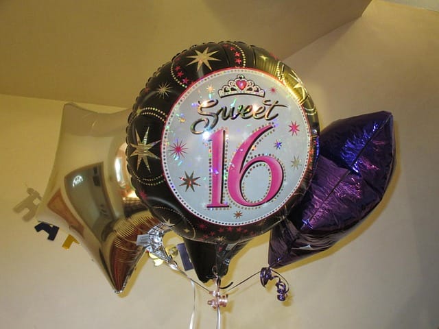 Sweet 16 birthday photo shoot decorations with shiny balloons and party setup