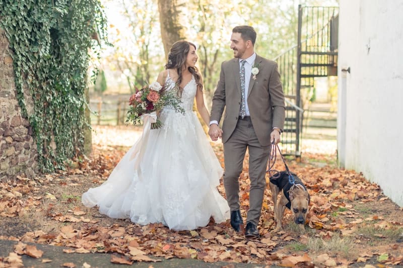 Bride and groom walking through fall foliage during autumn wedding photography