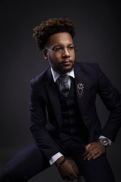 Man in a stylish suit with glasses, posing confidently for a professional headshot male.
